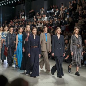 The image shows models walking the runway promoting the apparel industry.